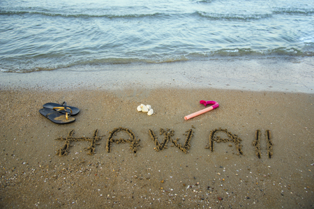 Hawaii written on the sand with snorkel an beach sleepersの写真素材