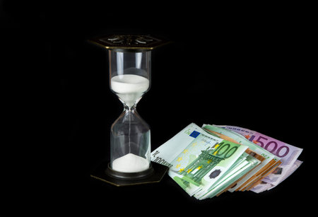 Hourglass and paper money. Time is money concept