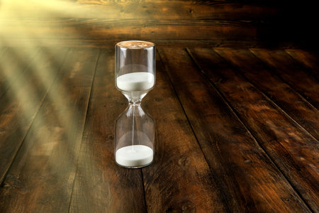 Hourglass on a wooden background. Time is money concept
