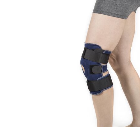 Man wearing knee orhtosis on a whiteの写真素材