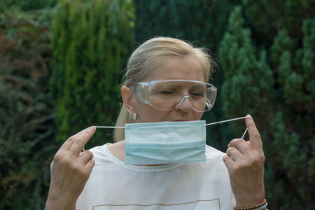 Mature woman wearing goggles and facemask. Coronavirus protection
