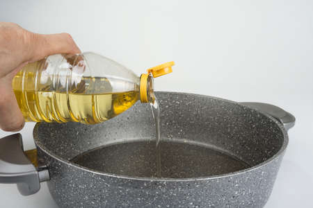 Vegetable oil in plastic bottle pouring in the panの写真素材