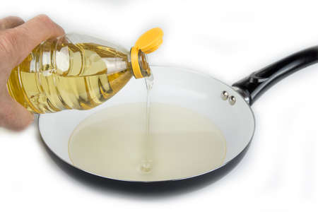 Vegetable oil in plastic bottle pouring in the panの写真素材