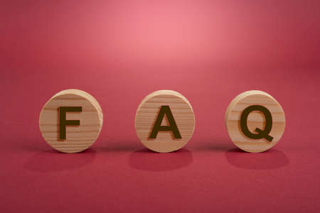Blank wooden circles for conceptual sign on a red. Frequently ask questionの写真素材