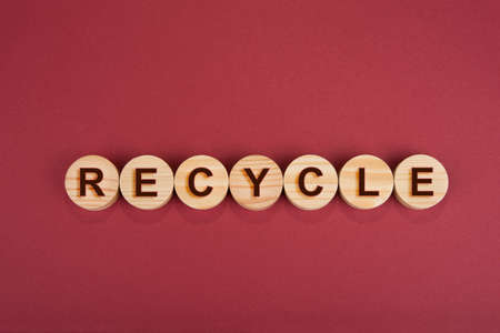 Recycle sign on a wooden circles on a redの写真素材