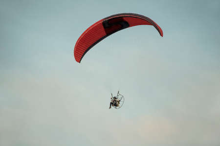 Paragliding flight in the overcast skyの写真素材
