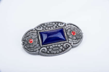 Brooch with a blue stone on a white backgroundの写真素材