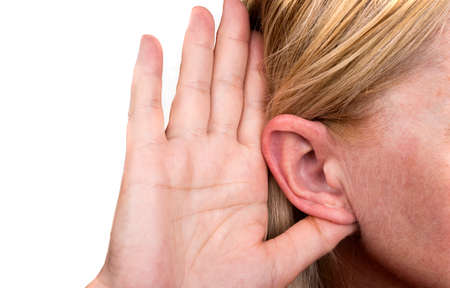 Woman is touching the ear to listen betterの写真素材