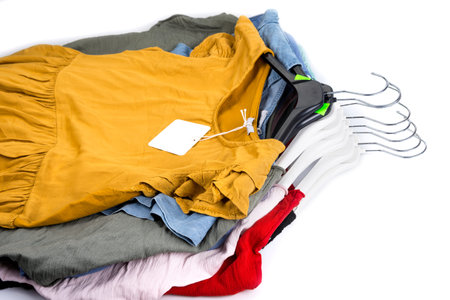 Stack of dresses on hangers on a whiteの写真素材