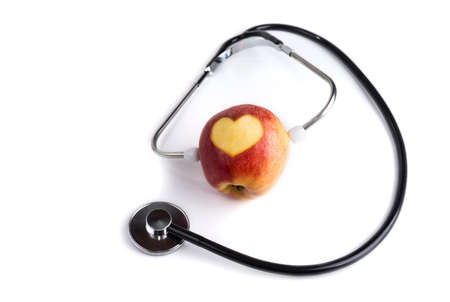 Carving heart on an apple with a stethoscope. Healthy lifestyle conceptの写真素材