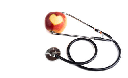 Carving heart on an apple with a stethoscope. Healthy lifestyle conceptの写真素材