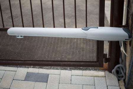 Arm swing electric opener on a older metal gateの写真素材