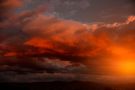 Dramatic sunset with dark clouds and orange sunburstの写真素材
