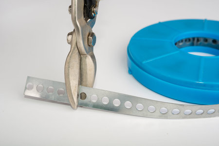 Perforated galvanized steel strip on a white