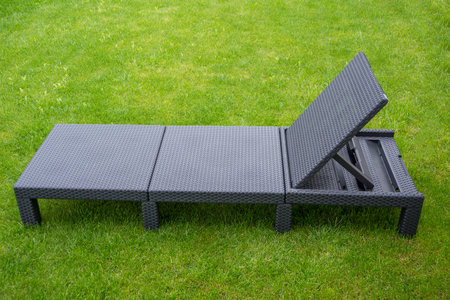 Plastic outdoor rattan bed on a lawnの写真素材
