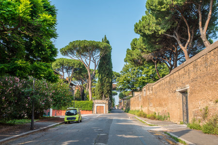 Green road in old historic city in Rome with a pine trees and small carの写真素材