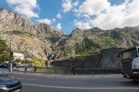 Taking photo on the Kotor bridge. Walls with a rock mountain and blue skyの写真素材