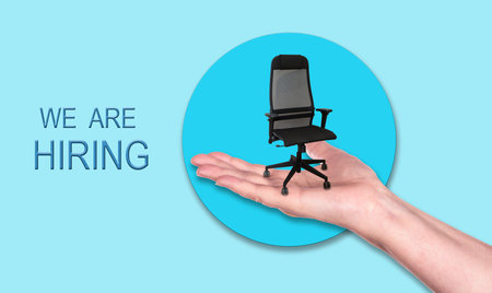 Manager office chair on a hand. We are hiring concept.の写真素材
