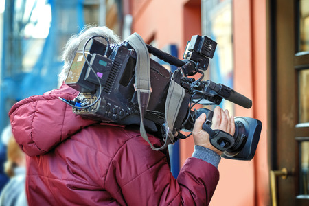 cameraman holding his professional camcorder in the streetの写真素材