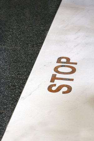 Stop sign on the line on the floor. Concept: stop line, deadline