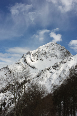 Mountains with snowy peaks and sky with cloudsの写真素材