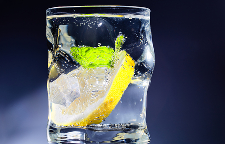 A slice of lemon and mint in a glass of water.の写真素材