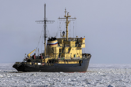 Icebreaker ship vessel in ice tries to break  between the glaciersの写真素材