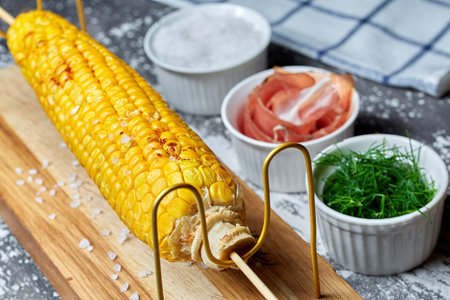 Grilled corn cob with bacon, salt and herbs. Grilled corn cob with bacon, salt and herbs.  Concept...