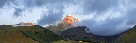 Panorama of the Mountain at dawn, the tents of tourists are on the hill, Georgia, Kazbekの写真素材