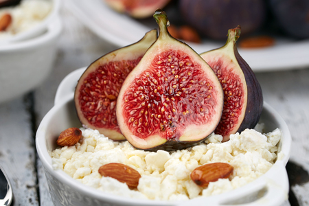 Cottage cheese with Figs and almonds in a white bowl on a light background. Concept: healthy Breakfastの写真素材