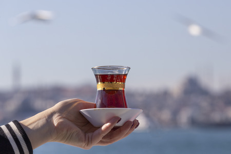 Hand holds a Cup of Turkish teaの写真素材