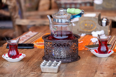 Turkish tea in traditional glasses on table. Traditional Turkish tea set: glass cup of tea, painted teapot.の写真素材