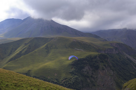 Paraglider flying over mountains.の写真素材