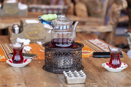 Turkish tea in traditional glasses on table. Traditional Turkish tea set: glass cup of tea, painted teapot.の写真素材