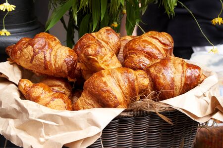 Croissants in a wicker basket on the counter, fresh croissantsの写真素材