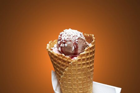 Chocolate ice cream on waffle cone on brawn or dark backgroundの写真素材