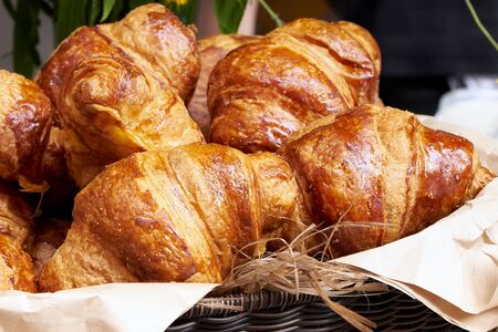 Croissants in a wicker basket on the counter, fresh croissantsの写真素材