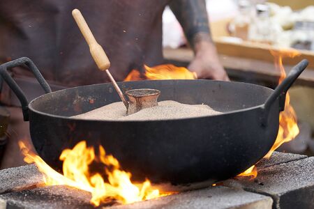 Turkish coffee made on a fire. man cooking turkish coffeeの写真素材