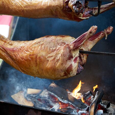 Two sheep carcasses are roasted on a spit outside on the fire. close upの写真素材