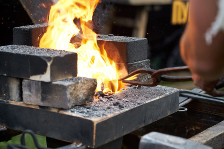 forge. blacksmith forges metal, splinters. blacksmith in the forging process in the open air