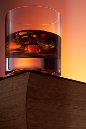 glass of whiskey with ice on an old book. bottom view. close up