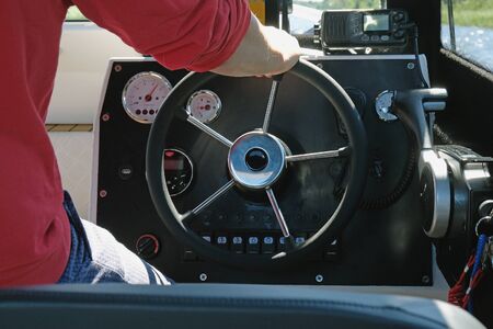 The captain at the wheel on the dashboard of the boatの写真素材