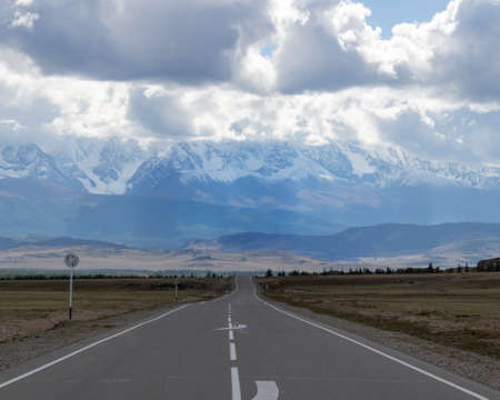 An asphalt road with white markings goes to the horizonの写真素材