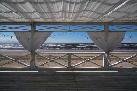 terrace with white curtains overlooking the seaの写真素材