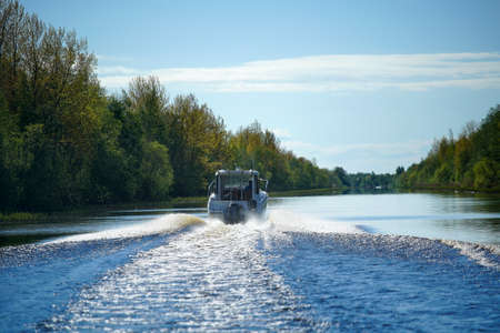 Motor boat floating on a forest river, rear view of a Sunnyの写真素材
