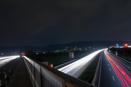 Speed Traffic - light trails on motorway highway at night, long exposure abstract urban backgroundの写真素材