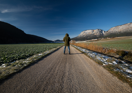 Traveler walking on a road in the fields of lower austriaの写真素材