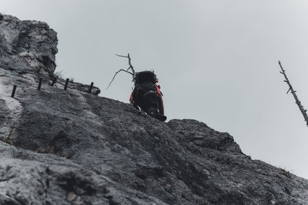 Image of young man mountaineer climbing on a rock in the mountainsの写真素材