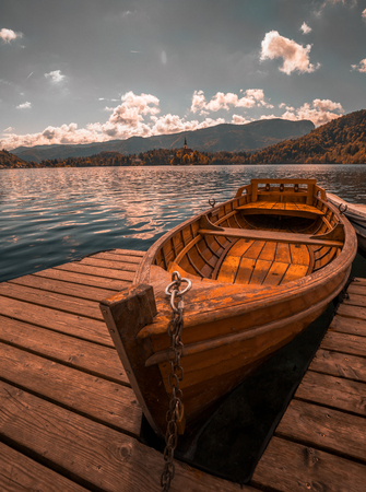 Traditional wooden boat Pletna on the backgorund of Church on the Island on Lake Bled, Slovenia. Europe.の写真素材