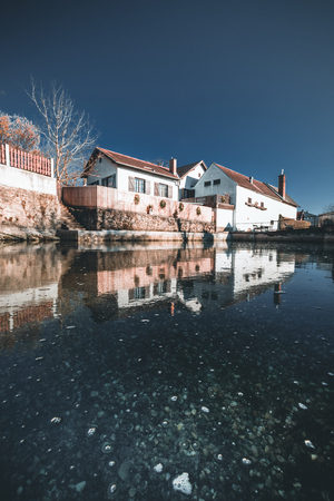 house in countryside near the lake with mirror reflection in water, bad fischau lower austriaの写真素材